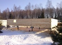 Начало возведения стен первого этажа брусового дома на свайно-винтовом фундаменте