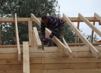 Подпиливание бруса для установки обрешетки