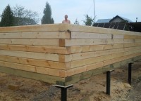 Угол брусового дома на свайном фундаменте
