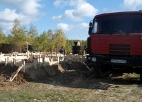 Процесс заливки раствора в траншею фундамента