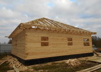 Установленная стропильная система на крыше дома из бруса с утеплением